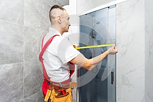 Worker measuring plastic window indoors. Installation process