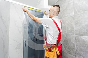 Worker measuring plastic window indoors. Installation process
