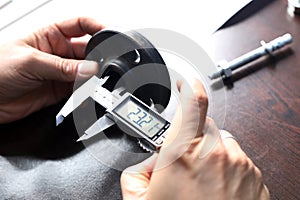 Worker is measuring to the diameter of the flange with a digital vernier caliper micrometer.
