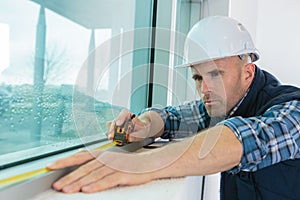 Worker measuring window at construction site