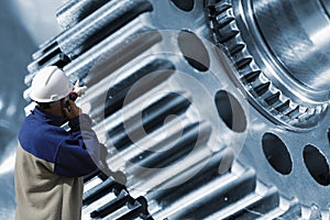 Worker, mechanic with giant gears and cogs