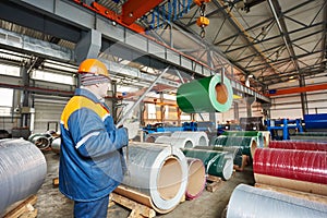 Worker at metal sheet profiling factory