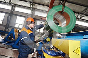 Worker at metal sheet profiling factory photo