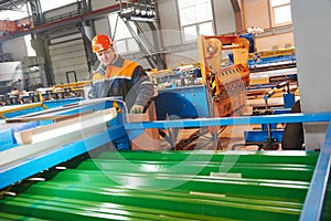 Worker at metal sheet profiling factory photo