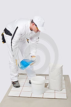 Worker mix tile adhesive bucket of water