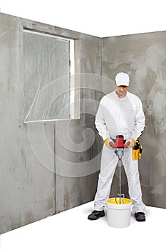 Worker mixing a plaster with a stirrer machine