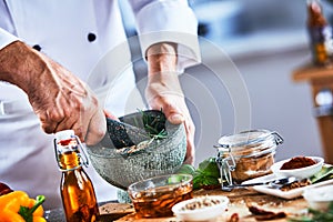 Worker mixing spices with mortar and pestle