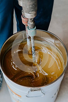 Worker mixing yellow epoxy resin with the mixer