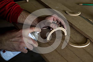 The worker is modeling part of the machine using wood