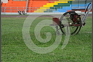 Worker mow lawn cutter in stadium