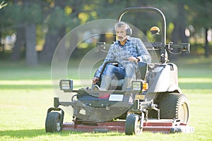 Worker mowing the park