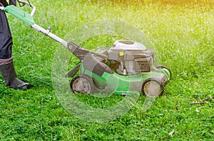 Worker mows the grass on the lawn in the park gasoline lawn mower