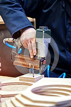 Worker with nailing gun in a workshop