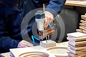 Worker with nailing gun in a workshop