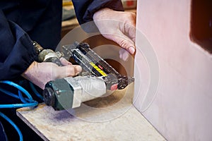 Worker with nailing gun in a workshop