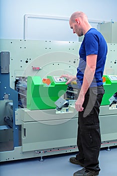 Worker next to the printing machine inputs the data by pressing the touch screen.