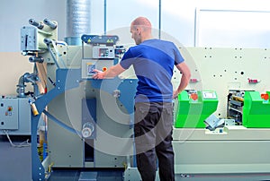Worker next to the printing machine inputs the data by pressing the touch screen.