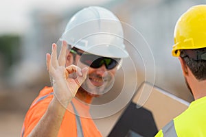 Worker with ok sign. Building concept. Builder foreman. Caucasian man construction worker in helmet at construction site