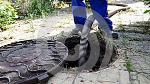 the worker opened the sewer hatch and inserted a hose for cleaning the septic tank. maintenance of communications in a