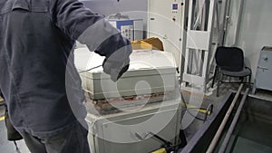 A worker opens the door of the tempering furnace. Quenching of steel billets. Metalworking shop.