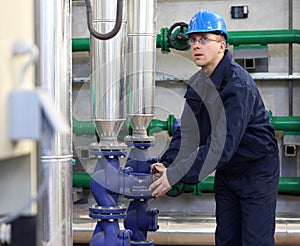 Worker opens a valve in plant