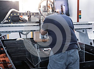 Worker operate CNC fiber laser cutting machine