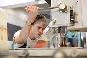 Worker operates glass drilling machine