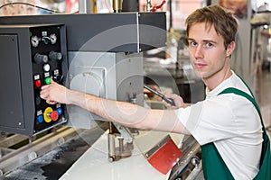 Worker operates glass drilling machine