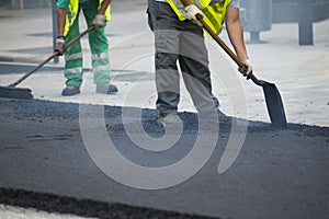 Worker operating asphalt paver machine