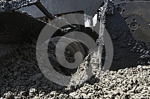 Worker operating asphalt paver machine during road construction and repairing works. A paver finisher, asphalt finisher