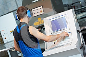 Worker operating cnc punch press