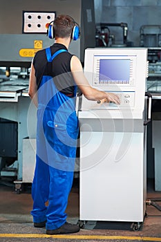 Worker operating cnc punch press