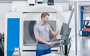 Worker operating computer-controlled machine tool