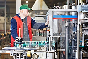 Worker operating conveyor or labeling machine at factory photo