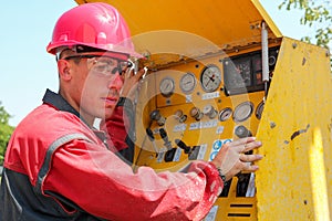 Worker Operating Drilling Rig Control Panel