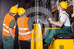 Worker operating forklift in warehouse