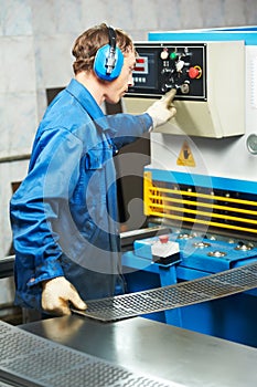 Worker operating guillotine shears photo