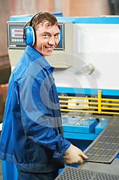 Worker operating guillotine shears photo