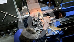 Worker operating in manual lathe