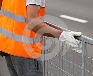 worker with orange high-visibility vest while moving the iron fe