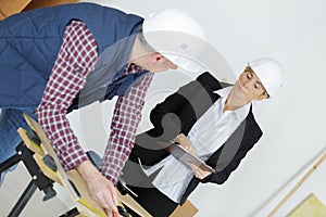 Worker with overseer controling stock in warehouse