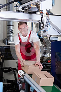 Worker packing boxes on conveyor belt