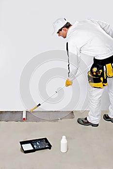 Worker paint with primer concrete