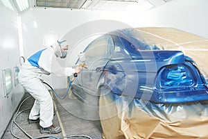 Worker painting auto car body