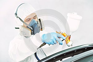 Worker painting auto car bumper