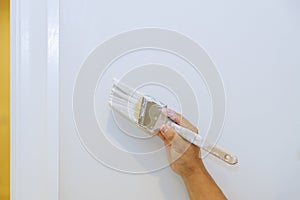 Worker are painting in the door trim molding on a white wall photo