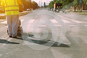 Worker is painting zebra pedestrian crosswalk