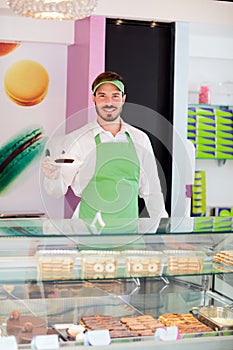 Worker in pastry shop holding cupcake