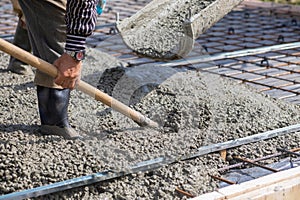 Worker picking up concrete with a shovel while