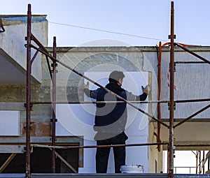 Worker placing styrofoam sheet insulation